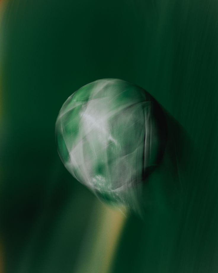 A ball in flight over deep green grass, caught in a long exposure